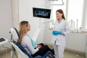Orthodontist consulting with a patient about self-ligating braces during an office visit