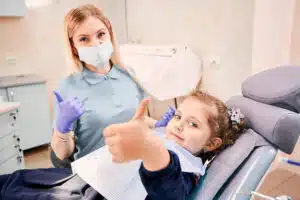 kid smiling during a braces checkup at the orthodontic office